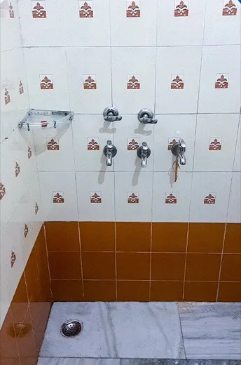 Bathroom with discoloured wall tiles and a grimy floor before cleaning, and the same bathroom with the tiles and floor cleaned